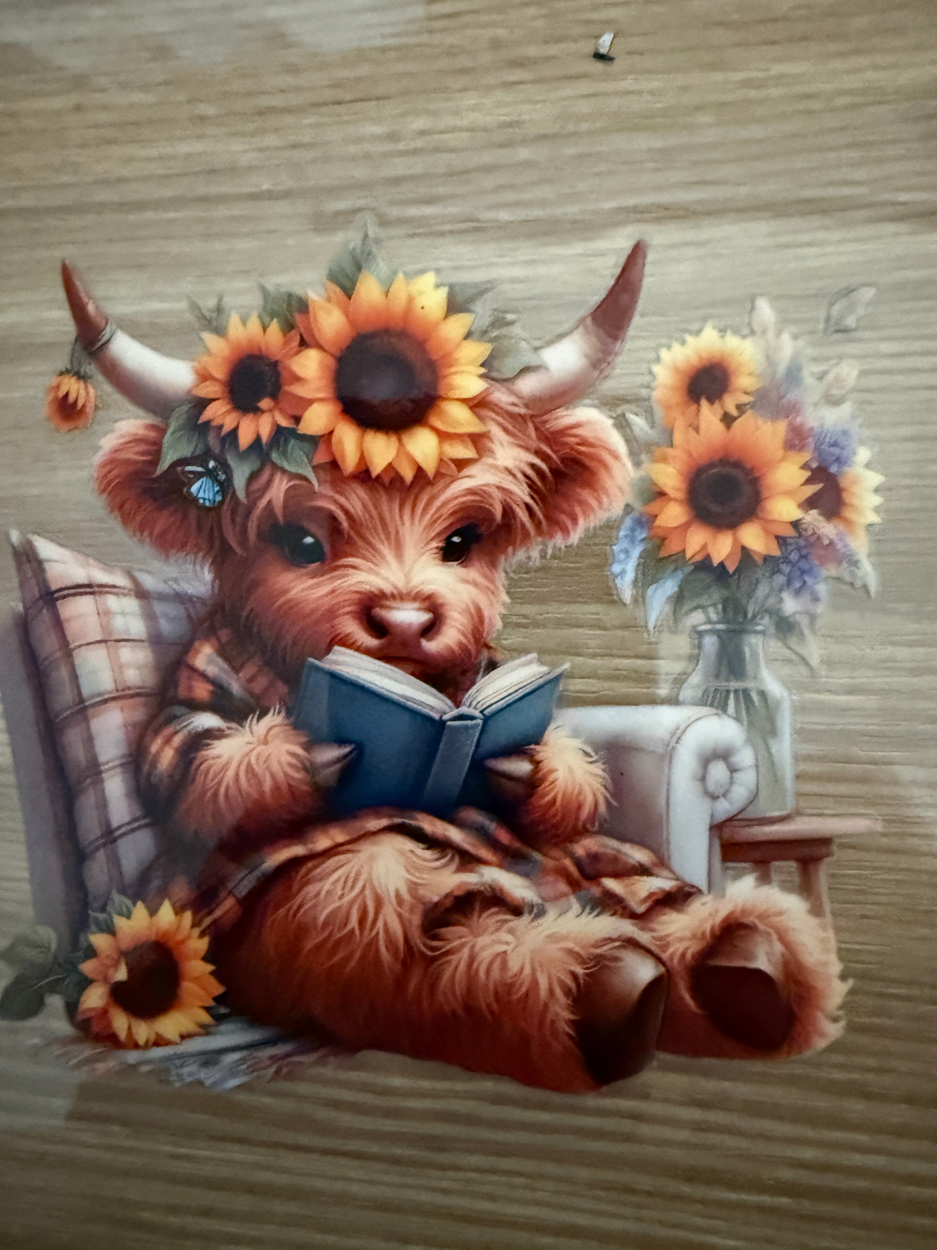Decal  - Cow reading a blue book while sitting in a chair